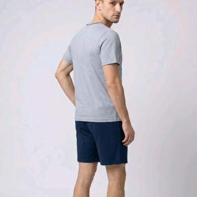 Homem de costas com t-shirt cinza e calções azul escuro