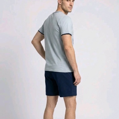 Homem de costas com t-shirt cinza e calções azuis escuros
