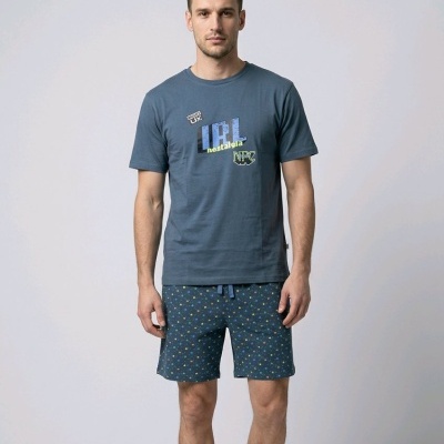 Homem com t-shirt azul com texto IRL nostalgia e calções azuis com padrão colorido