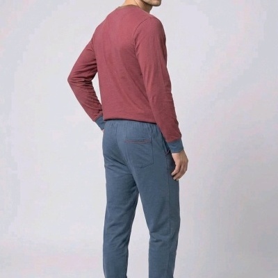 Homem de costas com camisola rosa escuro e calças azul-escuras em fundo branco