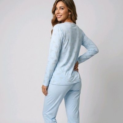 Pijama feminino azul claro com padrão de flocos de neve numa modelo a sorrir de costas