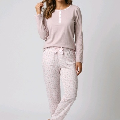 Mulher a usar pijama rosa claro com calças brancas de padrão floral e laço rosa