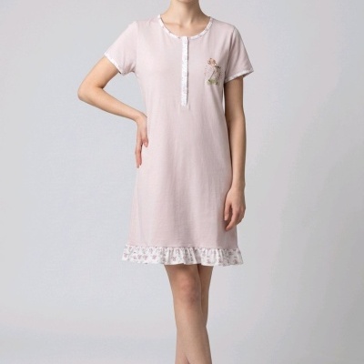 Vestido rosa claro com padrão floral na bainha e desenho de raposa, modelo em pé com sapatos rosa claro