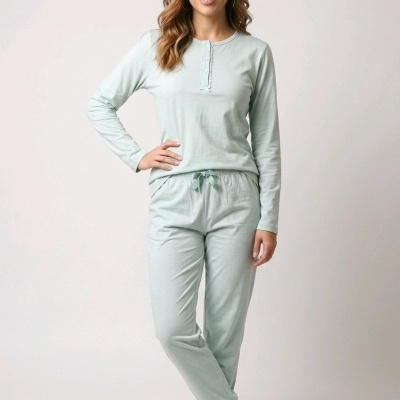 Mulher a usar pijama verde água com camisola de mangas compridas e calças com cordão.