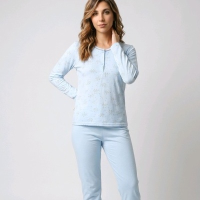 Mulher a usar pijama azul claro com padrão pequeno e calças lisas