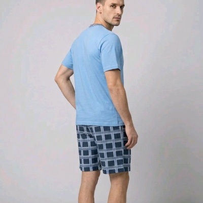 Homem com roupa casual azul com calções xadrez