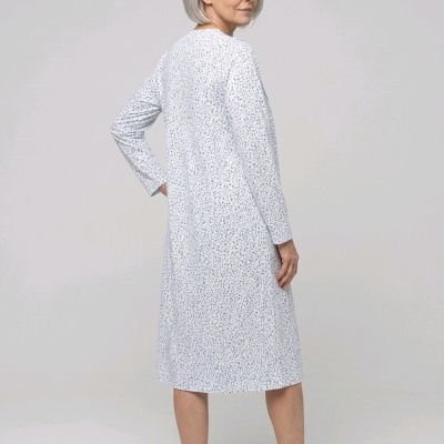 Mulher com camisola branca comprida de mangas compridas com padrão de pontos azuis
