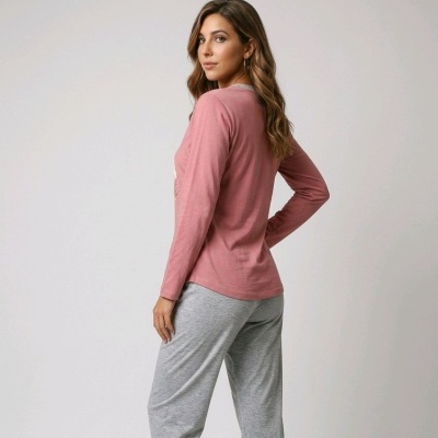 Mulher de pijama rosa e cinzento de costas, num fundo cinzento claro