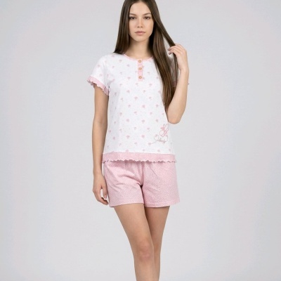 Mulher vestindo pijama branco e rosa com padrão floral, em fundo neutro
