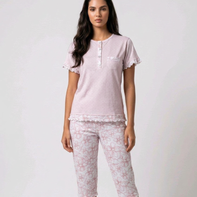 Mulher a usar pijama feminino com t-shirt rosa clara e calças capri brancas com padrão floral
