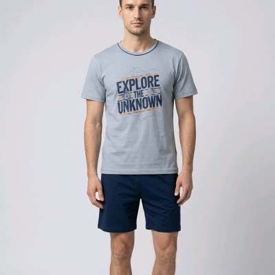 Homem a usar t-shirt cinzenta com texto e calções azuis escuros