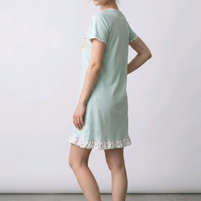 Vestido curto azul claro com detalhes florais brancos, mulher descalça