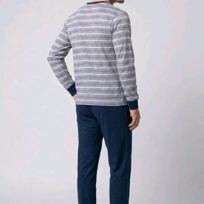 Homem de costas com pijama azul e riscas cinzentas e brancas