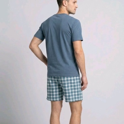 Homem de costas com t-shirt azul e calções xadrez azuis