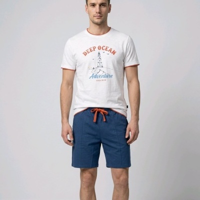 Homem com t-shirt branca estampada e calções azuis com cordão laranja