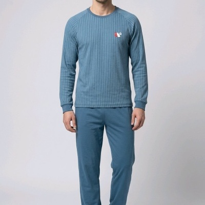 Homem com pijama azul de camisola riscada e calças lisas