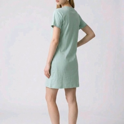 Vestido curto verde-água com detalhes em pérolas nas mangas, mulher vista de costas em fundo branco