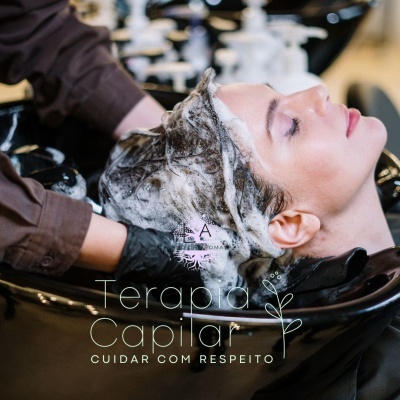 Mulher a receber terapia capilar com espuma no cabelo num lava-cabeças preto