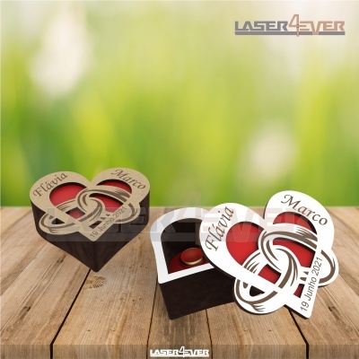 Caixa de madeira em forma de coração com tampa decorada e interior vermelho contendo um anel