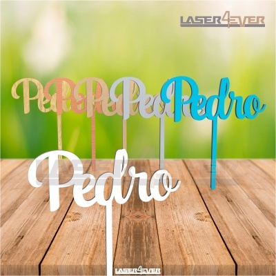 Decorações para bolos com o nome Pedro em várias cores sobre superfície de madeira