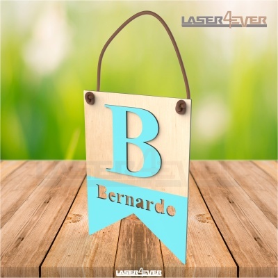 Placa decorativa de madeira com letra B azul e nome Bernardo numa superfície de madeira