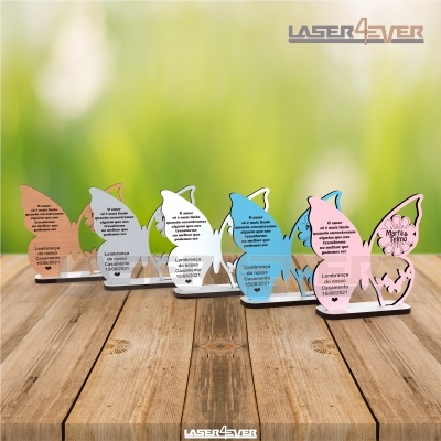 Lembranças de coelho em acrílico colorido com texto, sobre mesa de madeira