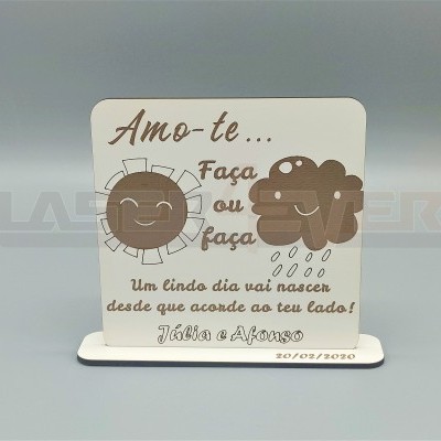 Placa decorativa branca com ilustrações de sol e nuvem e texto em português