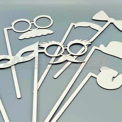 Acessórios para photobooth em papel branco sobre fundo cinza