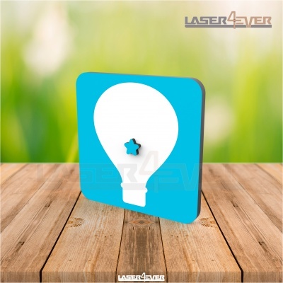 Placa azul com desenho branco de lâmpada e estrela azul no centro, sobre mesa de madeira