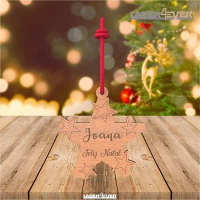Enfeite de Natal de madeira com cordão vermelho, formato estrela, texto gravado e fundo de árvore de Natal