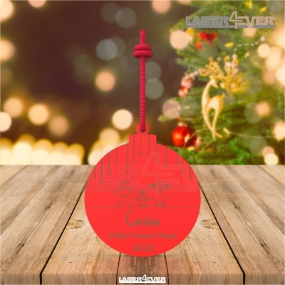 Ornamento de Natal vermelho com texto personalizado pendurado numa corda vermelha com árvore de Natal ao fundo