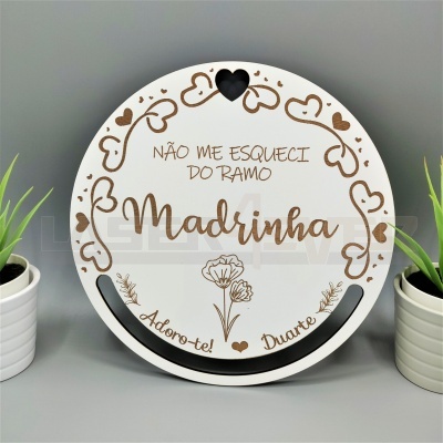 Placa redonda branca decorada com texto e corações, entre vasos brancos com plantas