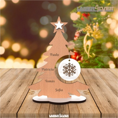 Sapin de Noël en bois clair avec étoiles et flocon de neige, noms gravés, décorations floues en arrière-plan