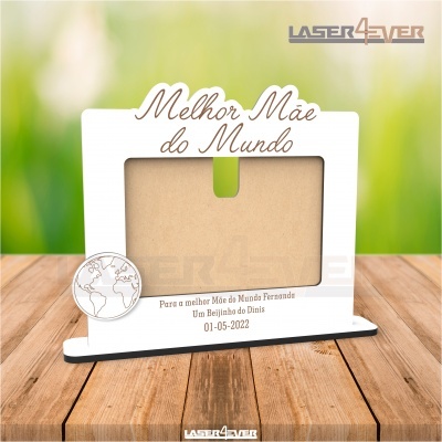 Moldura branca com texto para fotografia 'Melhor Mãe do Mundo' com base preta sobre madeira.