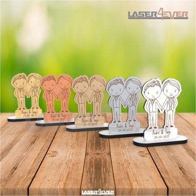 Figuras de casais em madeira personalizada gravada a laser em várias cores sobre mesa de madeira.