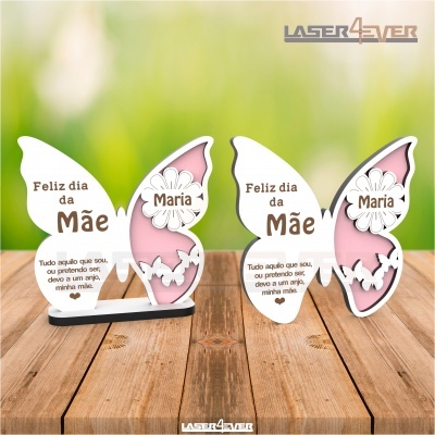 Enfeites de borboleta em madeira com texto Feliz dia da Mãe Maria sobre mesa de madeira