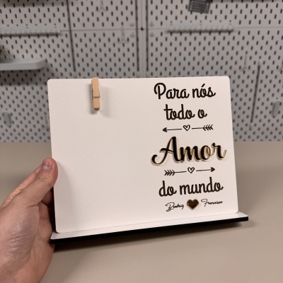Placa decorativa branca com texto amor e pregador de madeira