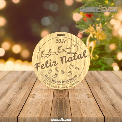 Disco de madeira gravado com mensagem de Natal e Ano Novo sobre mesa de madeira