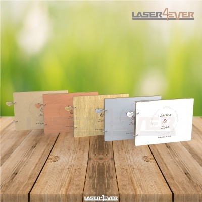 Convites de casamento variados sobre mesa de madeira com fundo verde desfocado