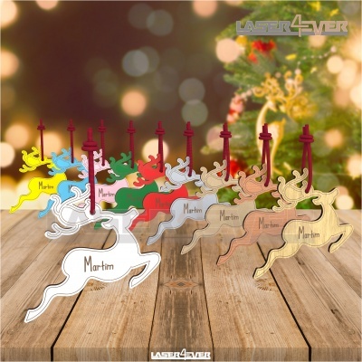 Decorações natalícias em forma de rena coloridas com nome 'Martim' em acrílico sobre mesa de madeira