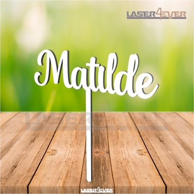 Topo de bolo em madeira branca com nome Matilde sobre mesa de madeira