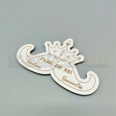 Peça decorativa em madeira branca com bigode e coroa, texto gravado 