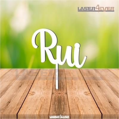 Topo de bolo branco com o nome Rui em acrílico numa superfície de madeira