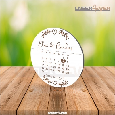Calendário redondo com nomes Elisa & Carlos e data julho de 2023, sobre mesa de madeira e fundo verde