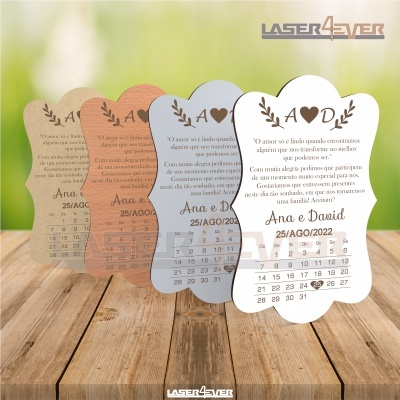 Quatro calendários de mesa decorativos com data e texto em diferentes cores e materiais sobre madeira