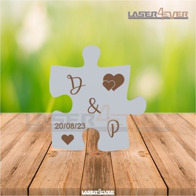 Peça de puzzle cinza com letras e corações sobre superfície de madeira