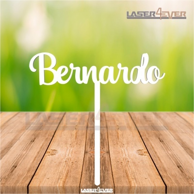 Objeto decorativo branco com nome 'Bernardo' em letra cursiva sobre madeira rústica