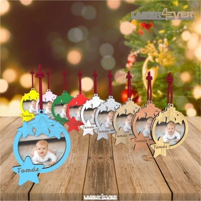 Conjunto de 11 molduras decorativas coloridas com fotos de bebés e nome Tomás, penduradas em cordões vermelhos, sobre mesa em madeira com decoração natalícia.