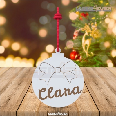 Bola de Natal branca personalizada com nome Clara e laço, pendurada com cordão vermelho junto a uma árvore de Natal