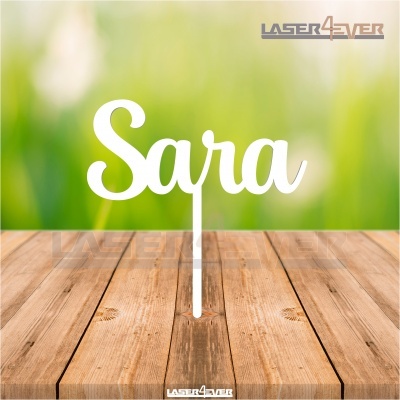 Topo de bolo branco personalizado com o nome Sara sobre mesa de madeira clara